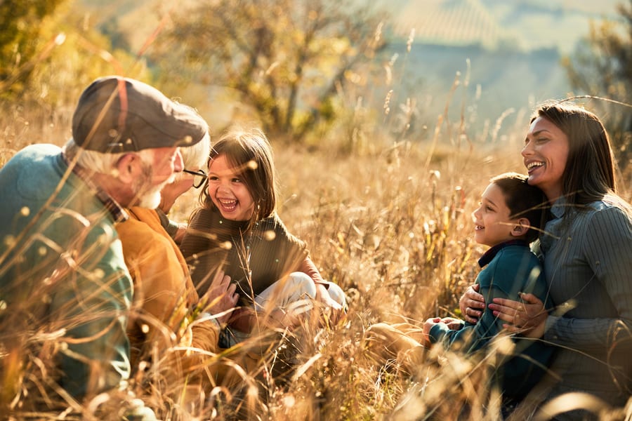 A multigenerational family walking through an autumn meadow