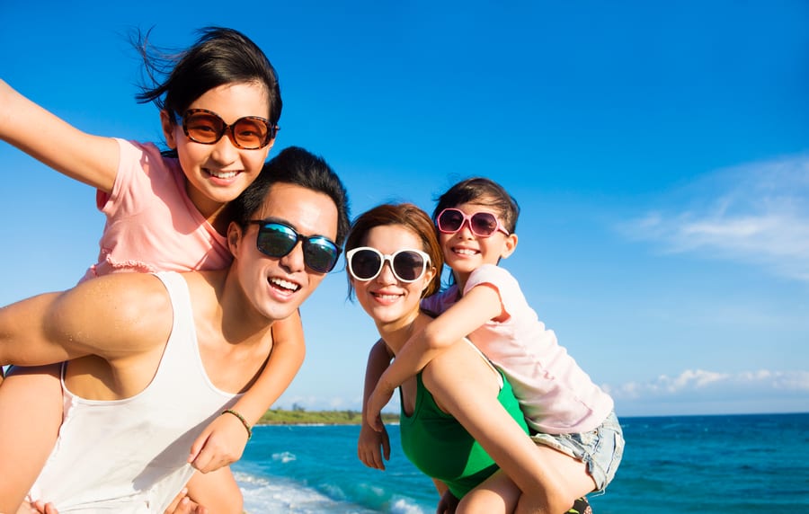A family playing on a beach at sunset